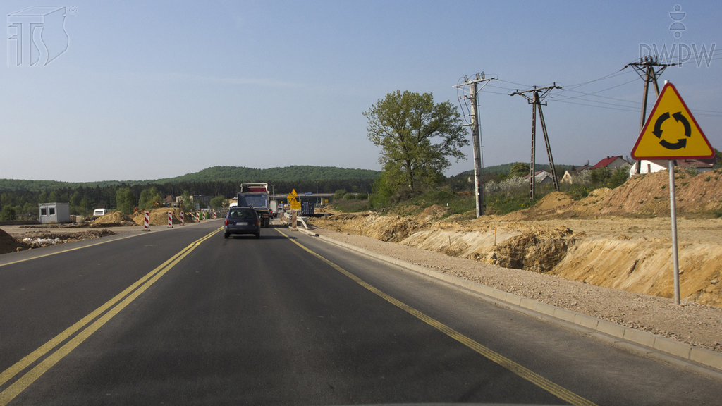In the presented situation, are you warned of an intersection in which the traffic flows around a traffic island or a square in the direction indicated on the sign?