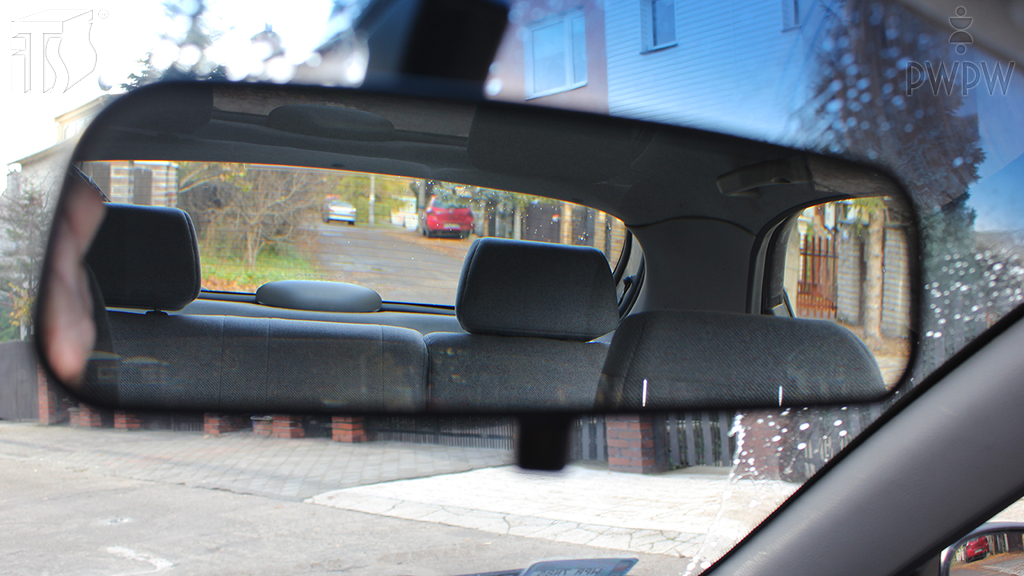 How should you properly position the rear-view mirror?