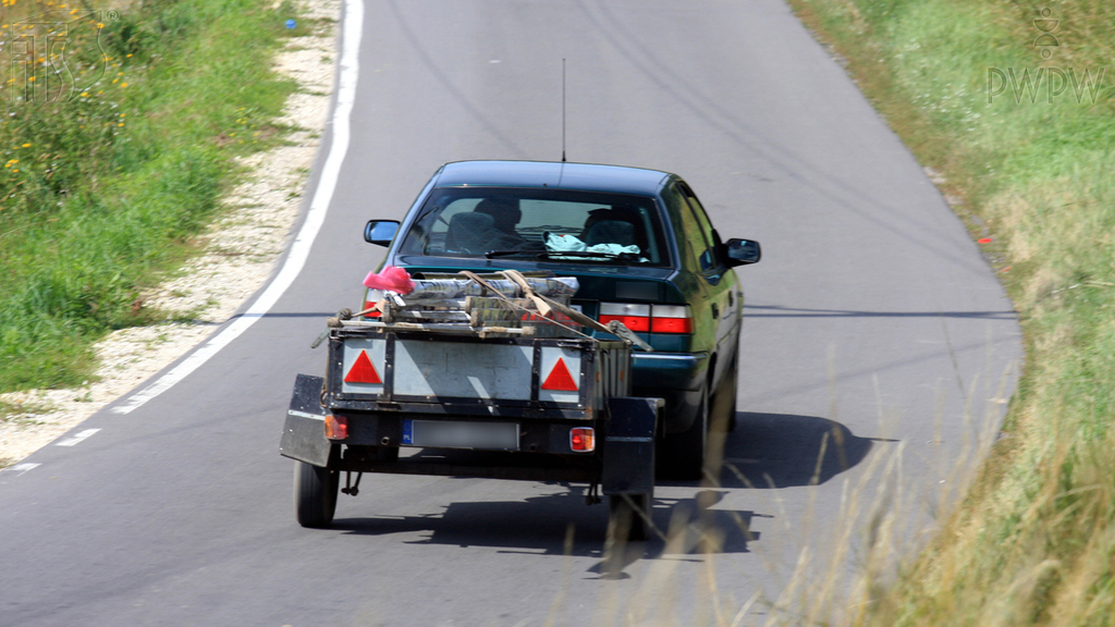 What is the maximum overhang of a load transported in a motor vehicle, counting from the rear outline of the car?