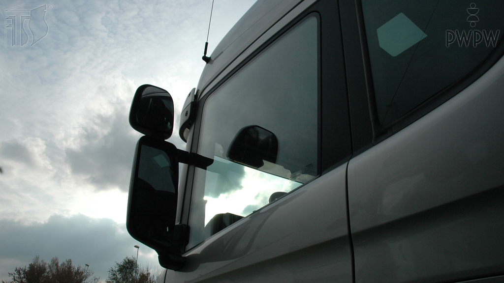 While driving a truck, what should you see in properly-adjusted external mirrors ("rear-view mirrors")?