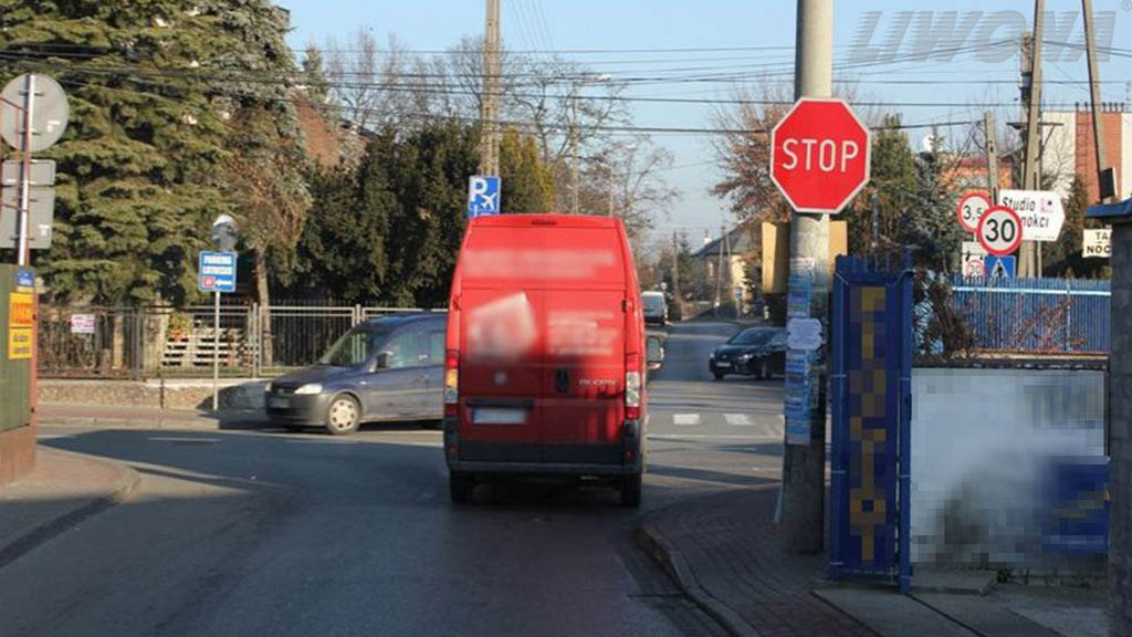 Stopping the vehicle at this intersection should occur before the "STOP" sign?