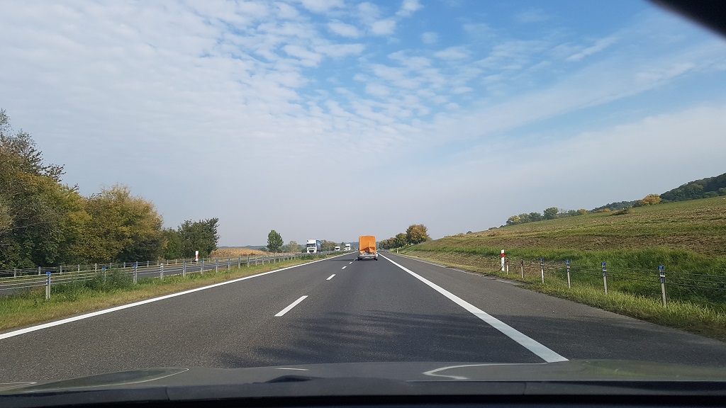 What is the maximum speed the driver of a passenger car with a trailer is permitted to travel on this road outside built-up areas?